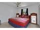 This bedroom features a stylishly decorated bed, a ceiling fan, and natural light from the window at 874 Quarters Ct, Port Orange, FL 32129