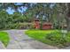 Beautiful home surrounded by mature trees, featuring a paved driveway and lush green lawn at 874 Quarters Ct, Port Orange, FL 32129