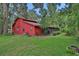 The backyard of this red home is surrounded by trees at 874 Quarters Ct, Port Orange, FL 32129