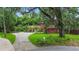 Charming home featuring a circular driveway and a lush front yard with mature trees at 874 Quarters Ct, Port Orange, FL 32129
