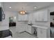 Bright kitchen featuring white cabinetry and countertops, stainless steel sink, and pendant lighting fixture at 874 Quarters Ct, Port Orange, FL 32129