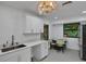 Well-lit kitchen featuring white cabinetry, countertops, stainless steel sink and dining area, promoting style at 874 Quarters Ct, Port Orange, FL 32129