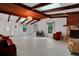 Open living area featuring a stone fireplace, beamed ceilings, tile floors, and bright windows at 874 Quarters Ct, Port Orange, FL 32129