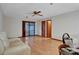 A well-lit living room features wood flooring, a ceiling fan, and sliding glass doors at 874 Quarters Ct, Port Orange, FL 32129