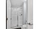 Bathroom featuring a glass-enclosed shower, white tile, and updated fixtures at 8961 Cabot Cliffs Dr, Davenport, FL 33896