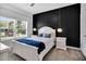 Cozy bedroom features a queen bed, modern lighting, and a large window at 8961 Cabot Cliffs Dr, Davenport, FL 33896