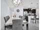 Dining room features modern chandelier, a white dining table and sleek tile flooring at 8961 Cabot Cliffs Dr, Davenport, FL 33896