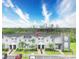 Modern townhome with gray exterior, landscaped front yard, and parking, under a bright blue sky at 8961 Cabot Cliffs Dr, Davenport, FL 33896