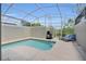Screened-in pool area with lounge chairs and a grill for outdoor entertaining at 8961 Cabot Cliffs Dr, Davenport, FL 33896