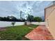 Large grassy backyard with a red brick patio, vinyl fence, a small shed, and mature trees at 1001 Golfside Ct, Kissimmee, FL 34741
