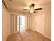 Bedroom with tile floors features a ceiling fan and sliding glass doors at 1001 Golfside Ct, Kissimmee, FL 34741
