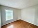 This bedroom features wood flooring, a large window, and neutral walls at 1001 Golfside Ct, Kissimmee, FL 34741