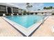 Beautiful community swimming pool surrounded by lounge chairs, palm trees, and well-maintained landscaping at 1221 S Pine Ridge Cir # A2, Sanford, FL 32773