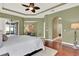 Spacious bedroom showcasing wood floors, tray ceiling, and access to an outdoor patio at 1375 Brayford Point, Deland, FL 32724