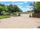 Paved driveway leading to a two-car garage, complemented by tropical landscaping and mature trees at 1405 Montclair Ct, Orlando, FL 32812