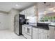 Functional kitchen space with black appliances, white cabinetry, and a breakfast bar open to the living area at 1405 Montclair Ct, Orlando, FL 32812