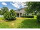 Backyard view of home with manicured lawn and trimmed hedges at 15318 Sandfield Loop, Winter Garden, FL 34787