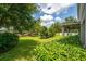 Expansive backyard featuring lush green lawn, mature trees and a covered patio area providing a relaxing outdoor living space at 15318 Sandfield Loop, Winter Garden, FL 34787