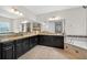 Bathroom with granite counters, dark cabinets, mosaic backsplash, and large mirrors at 15318 Sandfield Loop, Winter Garden, FL 34787