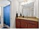 Bathroom showcasing a granite countertop, dark wood cabinetry, and a blue shower curtain in an alcove at 15318 Sandfield Loop, Winter Garden, FL 34787