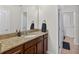 Bathroom featuring granite countertops, a sink, and a mirror with a door leading to another room at 15318 Sandfield Loop, Winter Garden, FL 34787