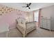 Charming bedroom with a pink accent wall decorated with flower accents and a coordinating floral bedding set at 15318 Sandfield Loop, Winter Garden, FL 34787