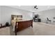 Bright bedroom with a cozy bed, home office setup, ceiling fan, and a space for exercise equipment at 15318 Sandfield Loop, Winter Garden, FL 34787