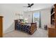 A bedroom featuring a wooden bed frame, ceiling fan, carpeted floor, and natural light from a window at 15318 Sandfield Loop, Winter Garden, FL 34787