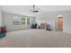 Spacious bonus room with neutral carpet, a ceiling fan, and multiple windows for ample natural light at 15318 Sandfield Loop, Winter Garden, FL 34787