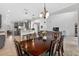 Dining room with a dark wood table, seating for six, chandelier, and an adjacent kitchen at 15318 Sandfield Loop, Winter Garden, FL 34787