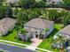 Beautiful two-story home with a well-manicured lawn, palm trees, and a brick driveway at 15318 Sandfield Loop, Winter Garden, FL 34787