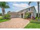 Charming home with brick driveway, manicured landscaping, and a two-car garage at 15318 Sandfield Loop, Winter Garden, FL 34787