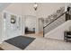 Grand foyer with tiled floors, a staircase adorned with Gathering photos, and a decorative front door at 15318 Sandfield Loop, Winter Garden, FL 34787