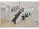 Bright foyer with staircase featuring decorative iron railing and a gallery wall with black and white photos at 15318 Sandfield Loop, Winter Garden, FL 34787