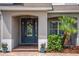 Close up view of the lovely blue front door, potted plants, and brick walkway to the home's entrance at 15318 Sandfield Loop, Winter Garden, FL 34787