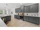 Well-equipped kitchen features stainless oven, microwave, and gas range, with white countertops and gray cabinets at 15318 Sandfield Loop, Winter Garden, FL 34787