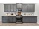 Kitchen with stainless oven and microwave, white countertops, subway tile backsplash, and gray cabinets at 15318 Sandfield Loop, Winter Garden, FL 34787