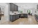 Kitchen area with stainless dishwasher, gray cabinets, tile flooring, white countertops, and an open view to the dining area at 15318 Sandfield Loop, Winter Garden, FL 34787