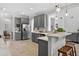 Bright open-concept kitchen featuring stainless appliances, bar stool seating, gray cabinets, and bright lighting at 15318 Sandfield Loop, Winter Garden, FL 34787