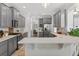 Bright kitchen features stainless appliances, gray cabinets, breakfast bar with a white countertop, and tile flooring at 15318 Sandfield Loop, Winter Garden, FL 34787