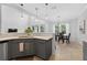 Kitchen area with gray cabinets, tiled floors, white countertops, and sink with bar seating and an open concept at 15318 Sandfield Loop, Winter Garden, FL 34787