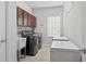 Laundry room with gray washer and dryer, storage cabinets and utility sink at 15318 Sandfield Loop, Winter Garden, FL 34787