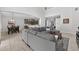 Spacious living room featuring a large gray sectional couch, tile floors, and views into the dining and kitchen areas at 15318 Sandfield Loop, Winter Garden, FL 34787