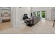Open living room features tile flooring, a large sofa, entertainment center, and bright natural lighting at 15318 Sandfield Loop, Winter Garden, FL 34787