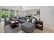 Bright living room featuring a large sectional sofa, a coffee table, and large windows at 15318 Sandfield Loop, Winter Garden, FL 34787