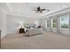 Spacious main bedroom boasts a tray ceiling, neutral carpet, large windows, and elegant decor at 15318 Sandfield Loop, Winter Garden, FL 34787