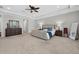 Spacious main bedroom with tufted king bed, ceiling fan, and and dresser at 15318 Sandfield Loop, Winter Garden, FL 34787