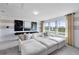 Bright living room with a large white sectional sofa and modern artwork, filled with natural light from three windows at 1549 Timber Leaf Rd, St Cloud, FL 34771