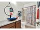 Nautical-themed bathroom featuring a blue vessel sink, gray countertops, and a shower with an ocean-themed curtain at 15613 Camp Dubois Cres, Winter Garden, FL 34787
