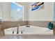 Modern corner tub with chrome fixtures and tile surround near the window at 15613 Camp Dubois Cres, Winter Garden, FL 34787